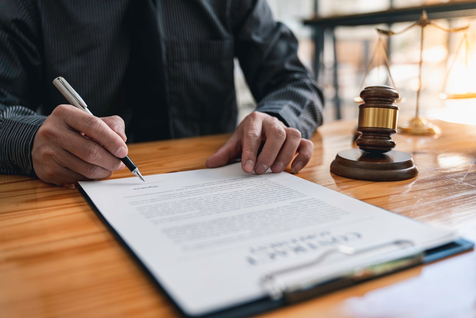 lawyer signing legal document at office desk
